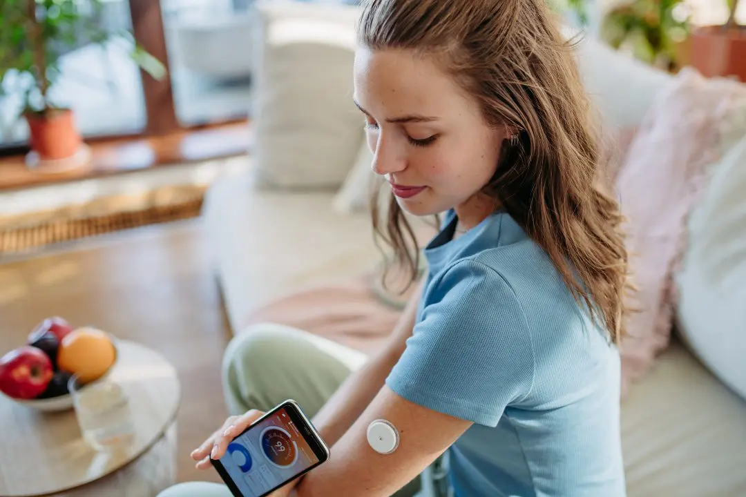 Young woman checking her CGM at home