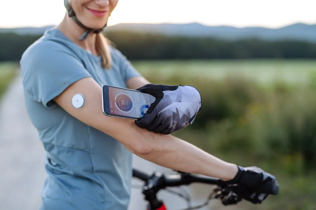 Woman checking her CGM while on a bike ride